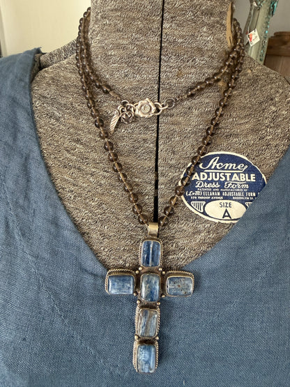 Blue kyanite cross on knotted smoky quartz necklace with fine silver flower accents.