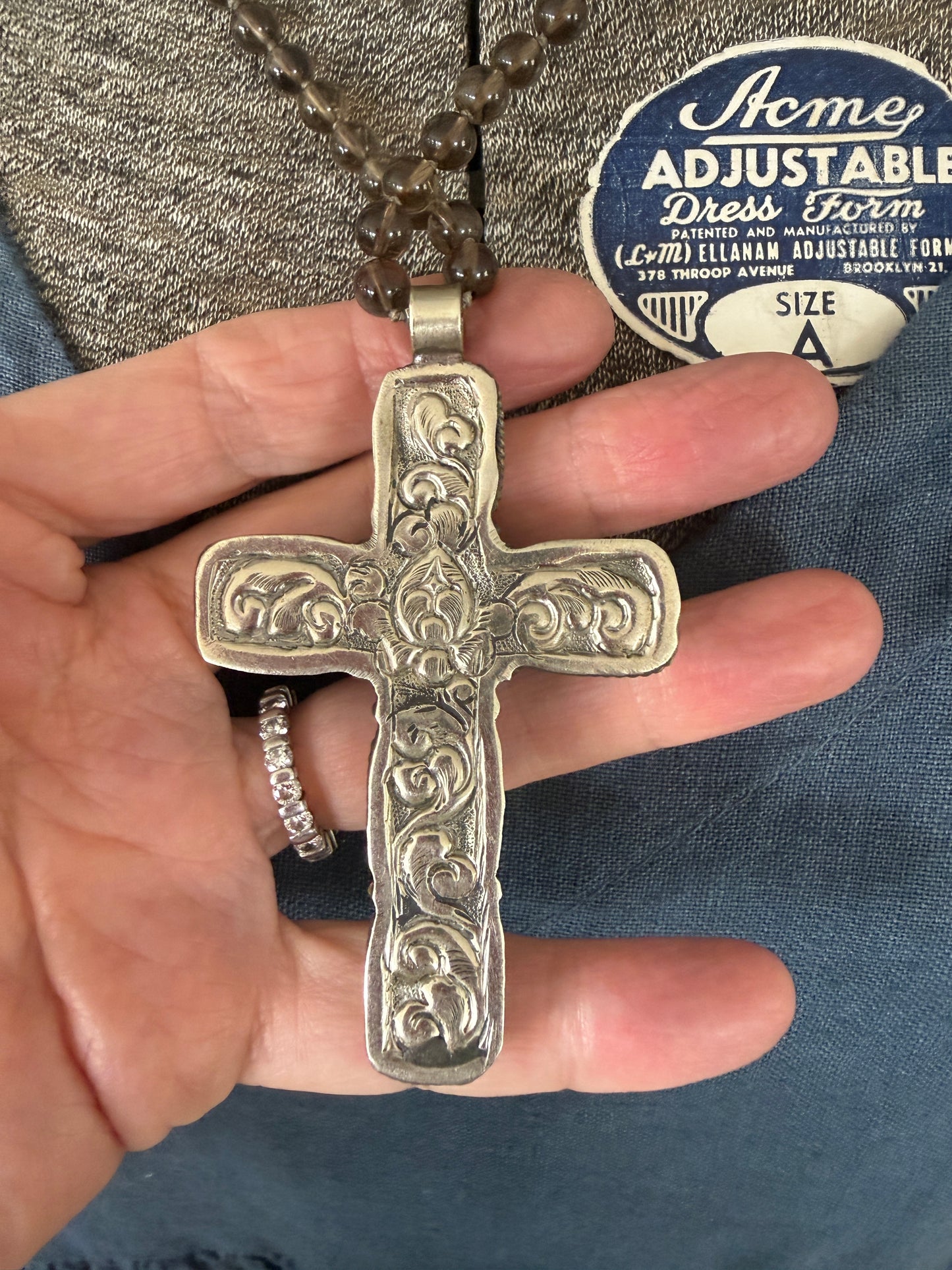 Blue kyanite cross on knotted smoky quartz necklace with fine silver flower accents.