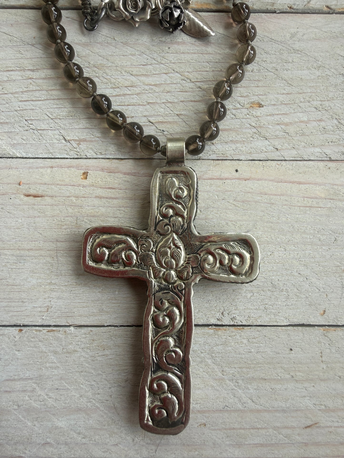 Blue kyanite cross on knotted smoky quartz necklace with fine silver flower accents.