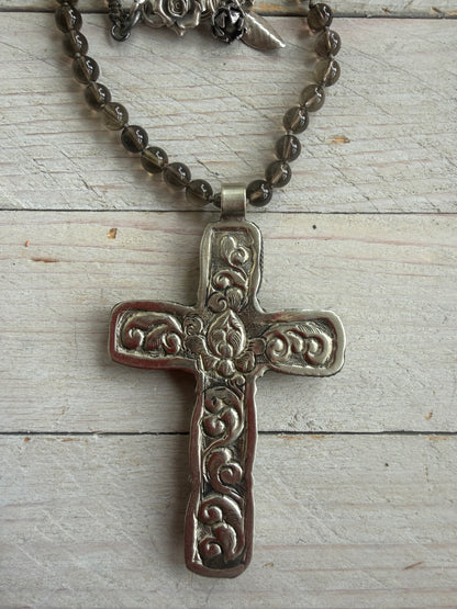 Blue kyanite cross on knotted smoky quartz necklace with fine silver flower accents.