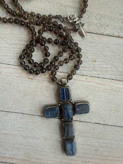 Blue kyanite cross on knotted smoky quartz necklace with fine silver flower accents.