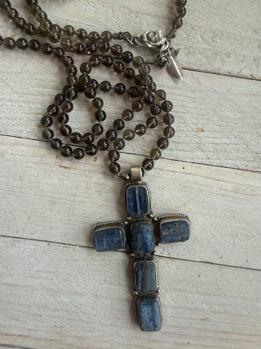 Blue kyanite cross on knotted smoky quartz necklace with fine silver flower accents.
