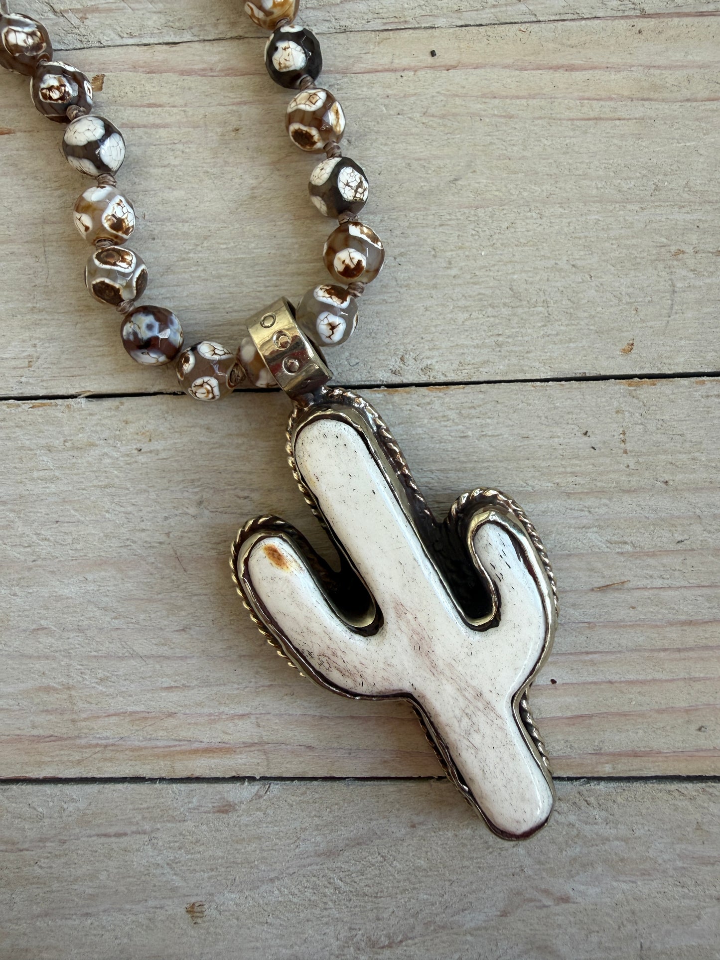Bone cactus pendant on Dzi agates with fine silver embellishments. 34.5”