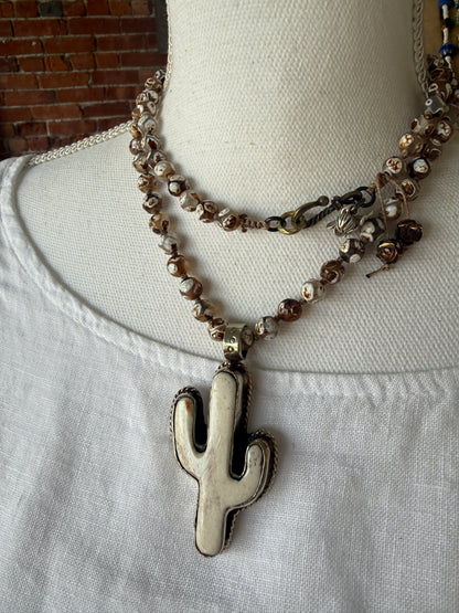 Bone cactus pendant on Dzi agates with fine silver embellishments. 34.5”