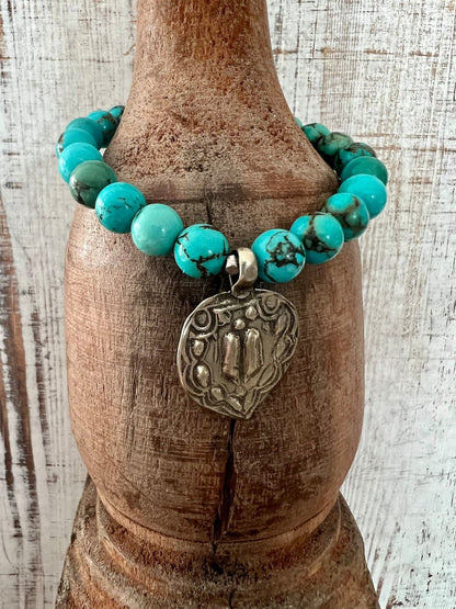 Lotus feet. Artisan made charm suspended on turquoise rounds stretch boho yogi bracelet. 7”