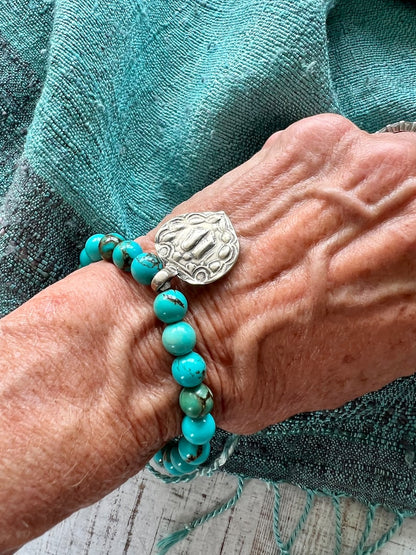 Lotus feet. Artisan made charm suspended on turquoise rounds stretch boho yogi bracelet. 7”