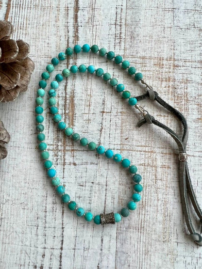 Matte turquoise beads with a pavé diamond barrel bead focal. Adjustable necklace with grey deerskin and fine silver accents. OOAK.