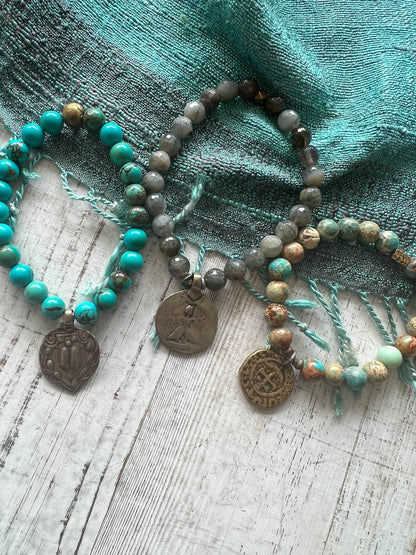 Lotus feet. Artisan made charm suspended on turquoise rounds stretch boho yogi bracelet. 7”