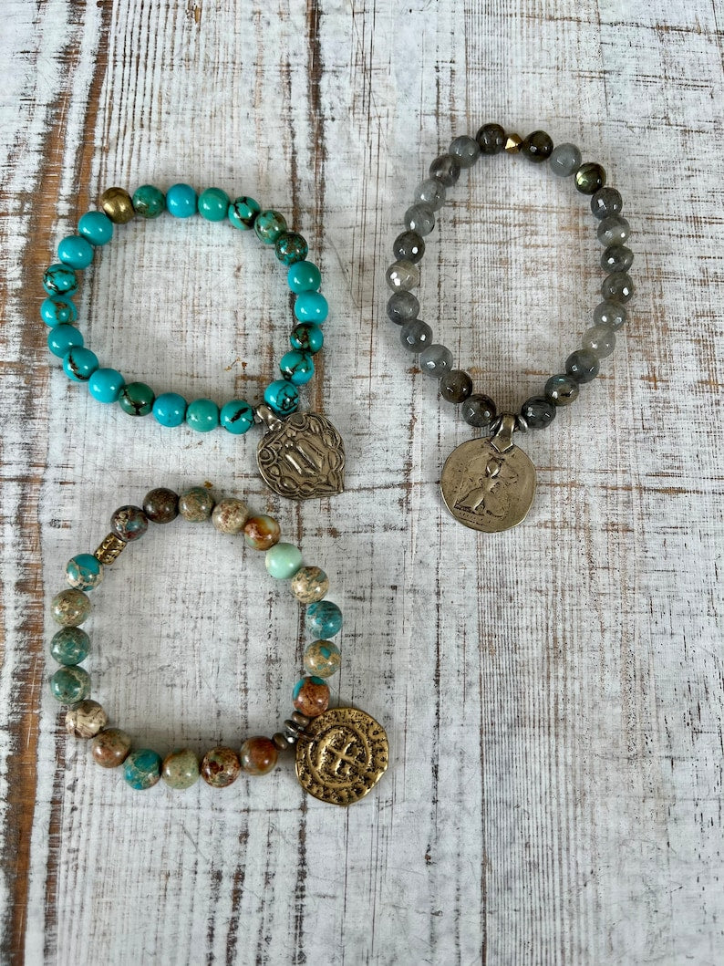 Lotus feet. Artisan made charm suspended on turquoise rounds stretch boho yogi bracelet. 7”