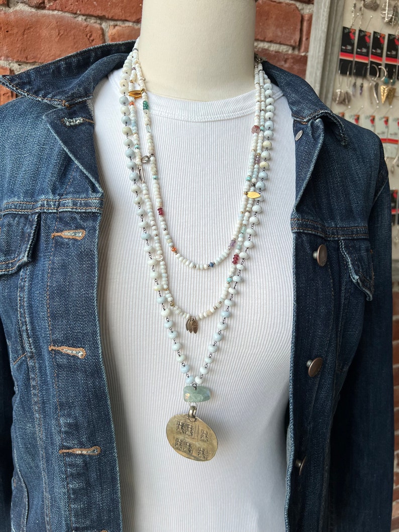 African opal chain with an artisan made bronze pendant and fluorite accents. Long, adjustable necklace.