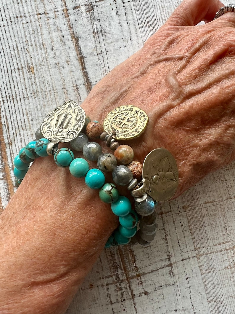 Lotus feet. Artisan made charm suspended on turquoise rounds stretch boho yogi bracelet. 7”