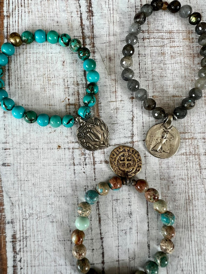 Lotus feet. Artisan made charm suspended on turquoise rounds stretch boho yogi bracelet. 7”