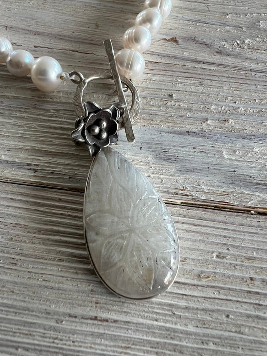 Carved moonstone pendant on hand knotted pearls with front toggle clasp