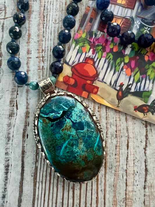 Tibetan turquoise repousé pendant hand-knotted on to lapis beads with a splash of turquoise. Extra long- wear doubled, too!