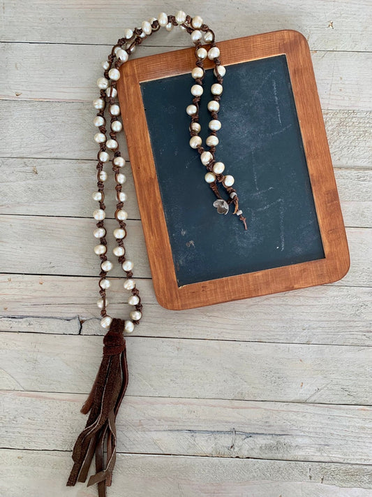 Fresh water champagne pearls hand-knotted on leather. Suede tassel. Fine silver button clasp.