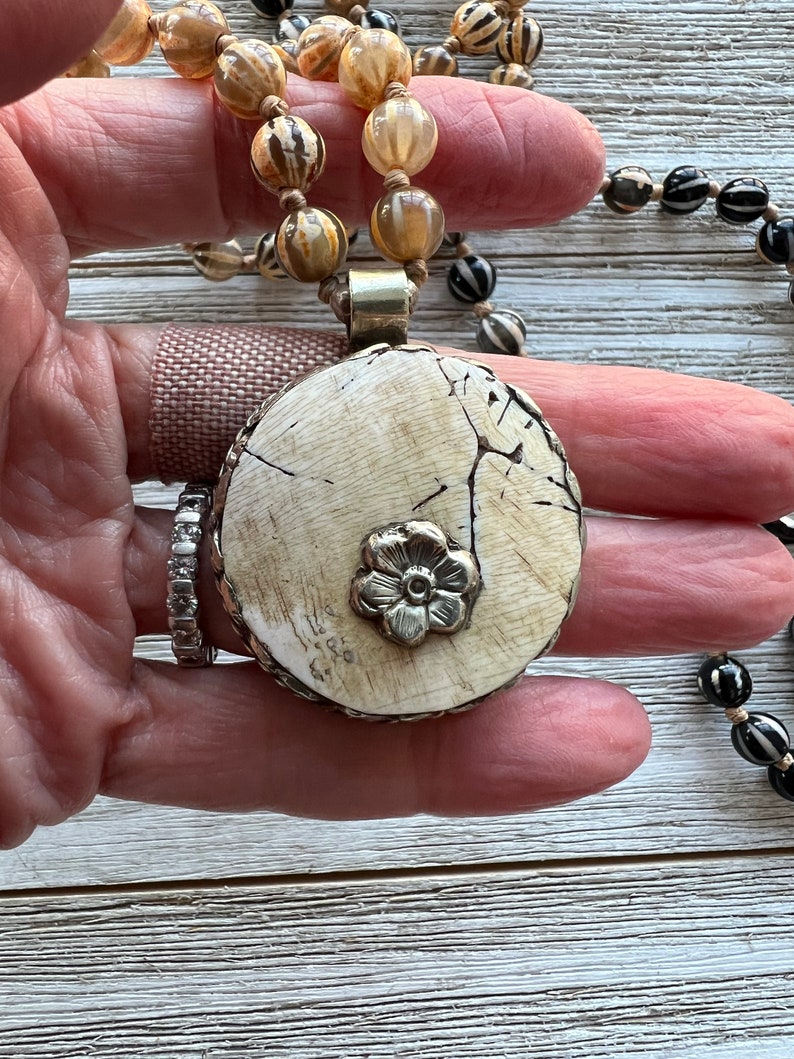 Tibetan bone round pendant knotted with Tibetan agates. Long, earthy boho necklace