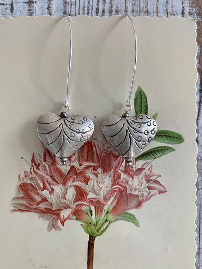 Fine silver stamped heart earrings on ellipse-shaped sterling ear wire. Sister, wife, daughter, gf gift