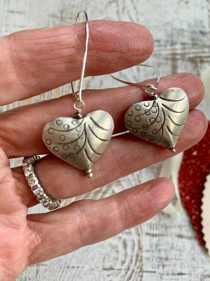 Fine silver stamped heart earrings on ellipse-shaped sterling ear wire. Sister, wife, daughter, gf gift