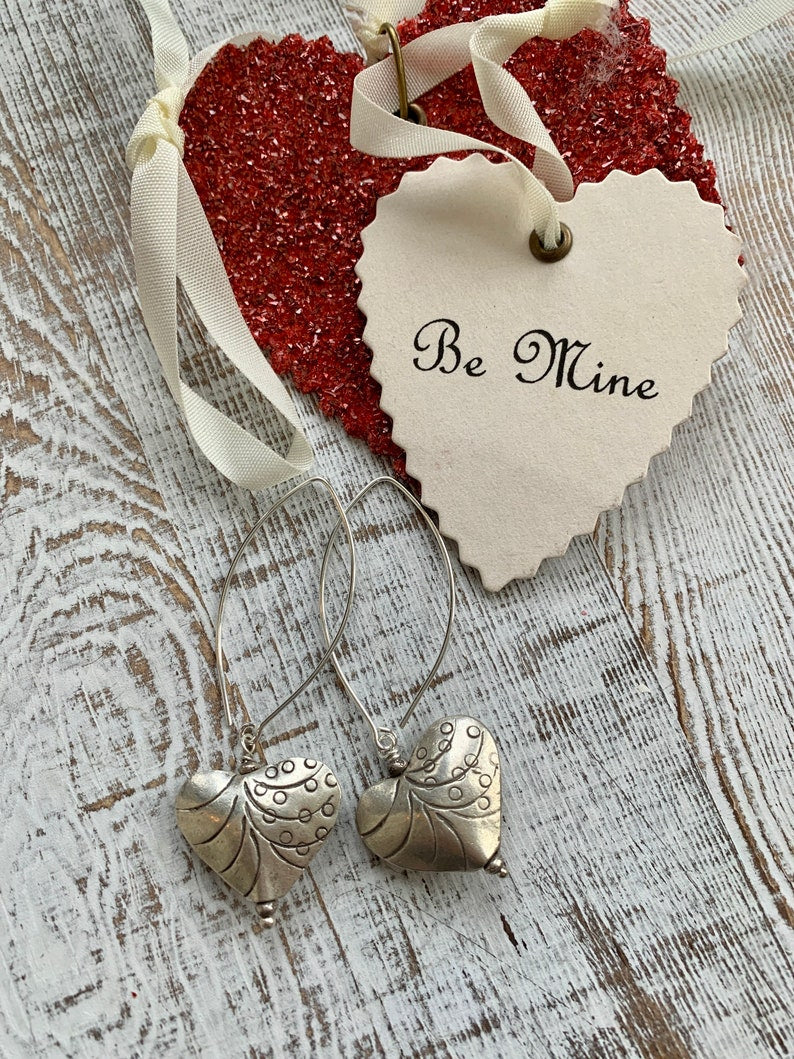 Fine silver stamped heart earrings on ellipse-shaped sterling ear wire. Sister, wife, daughter, gf gift