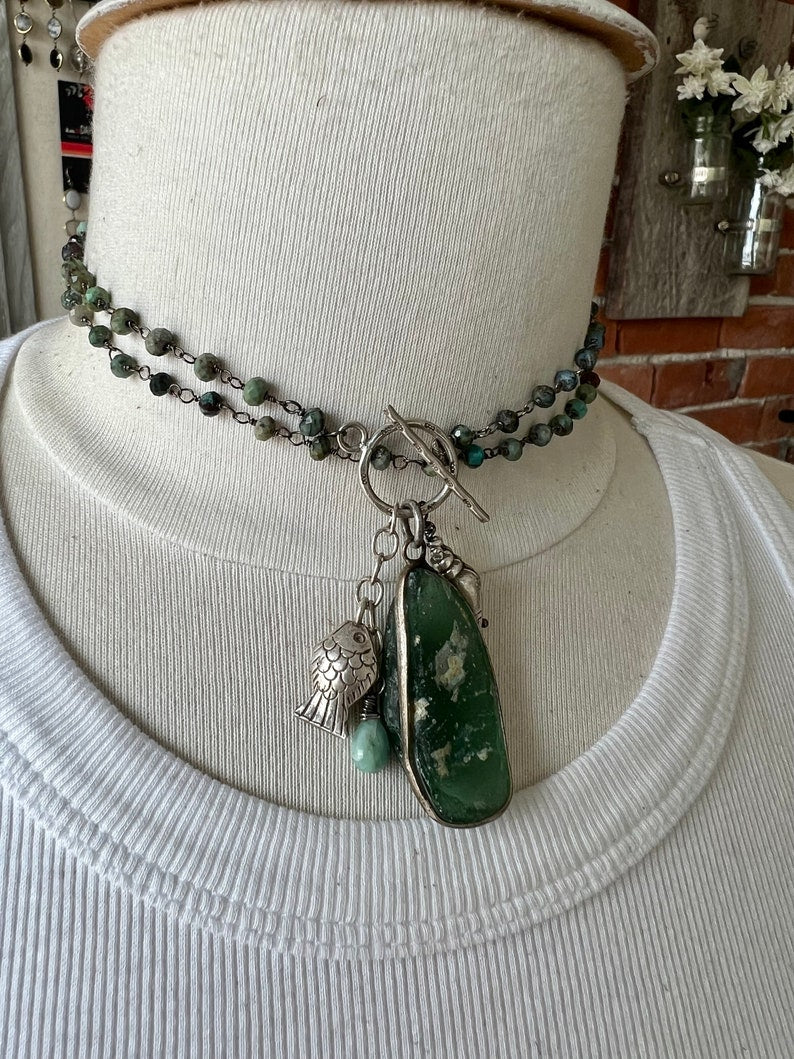 Ancient Roman glass with a beach vibe on tiny faceted turquoise chain. Fine silver shell, fish and stamped toggle.